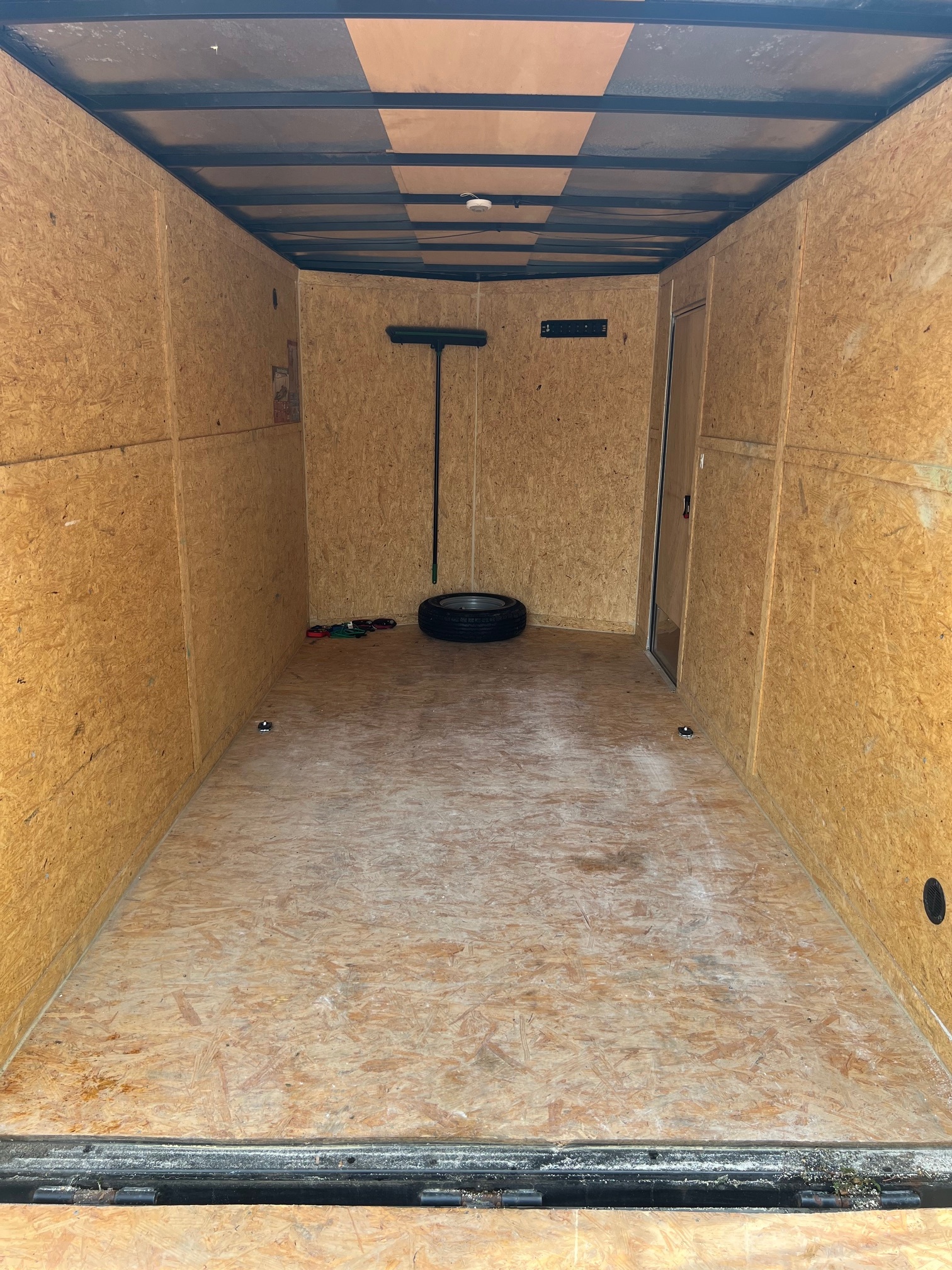 Interior view of enclosed trailer showing clean plywood walls and spacious cargo area